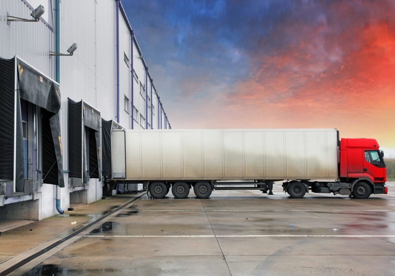 A large truck parked in front of a building.